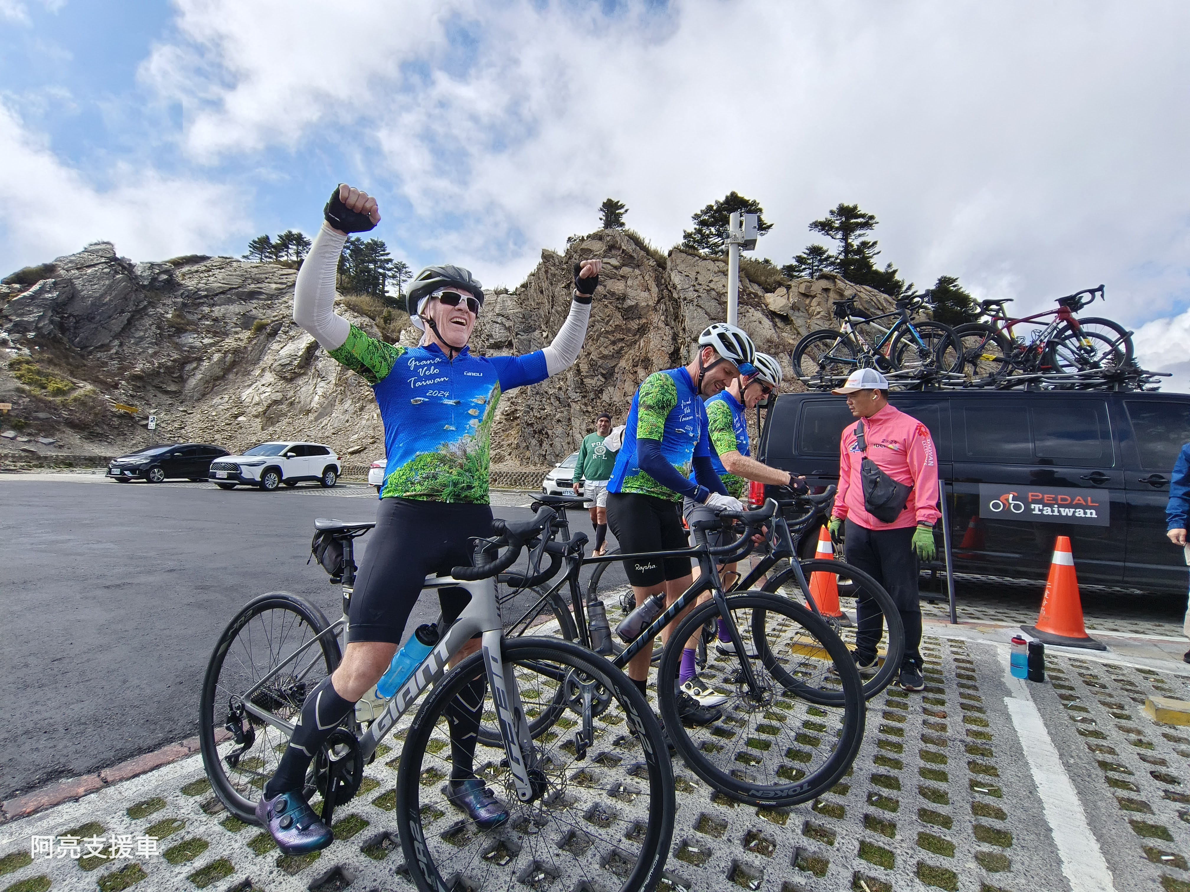 Cyclist celebrating at coastal mountain viewpoint