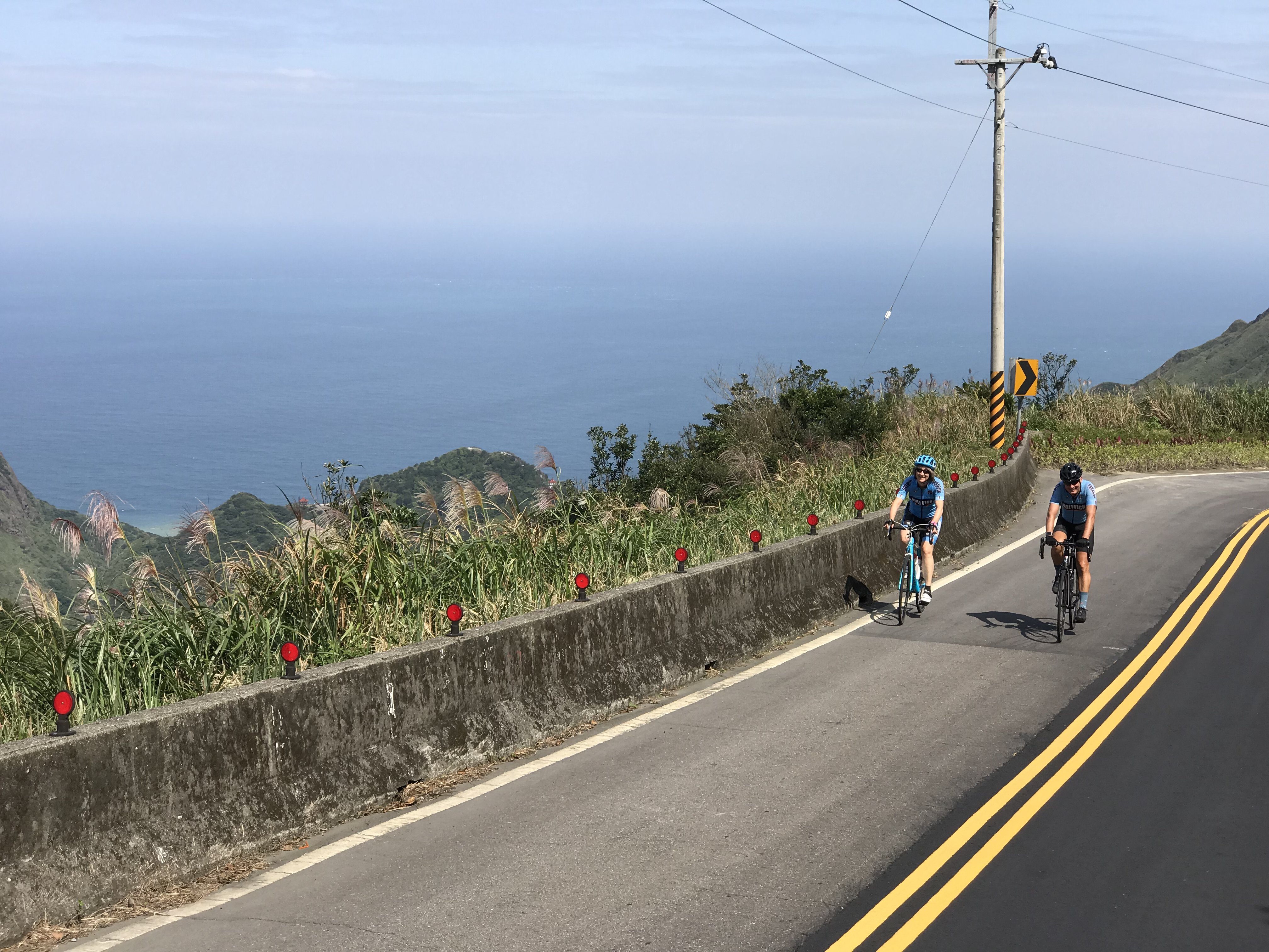 Two cyclists on a coastal mountain road