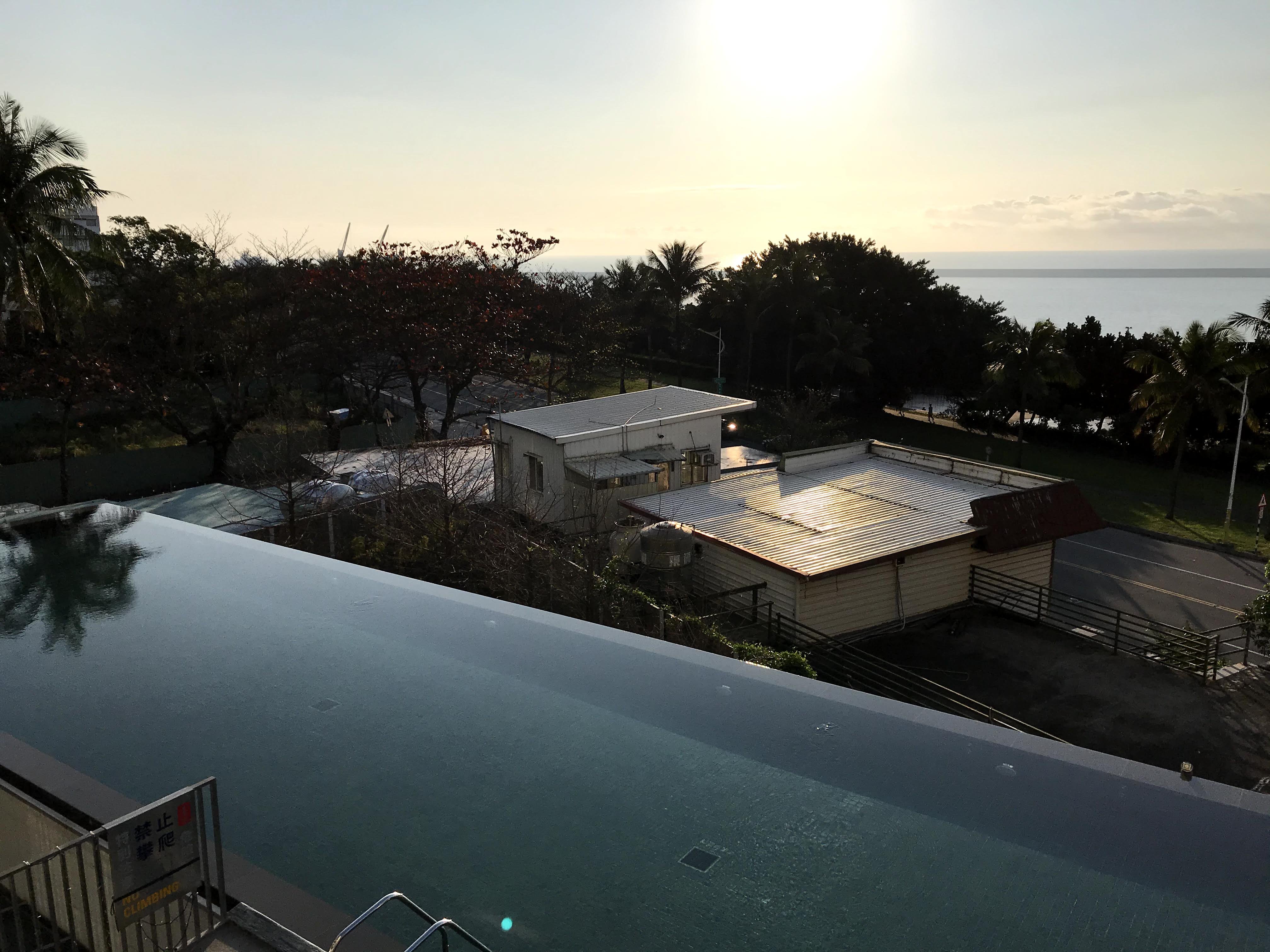 Infinity pool with coastal sunrise