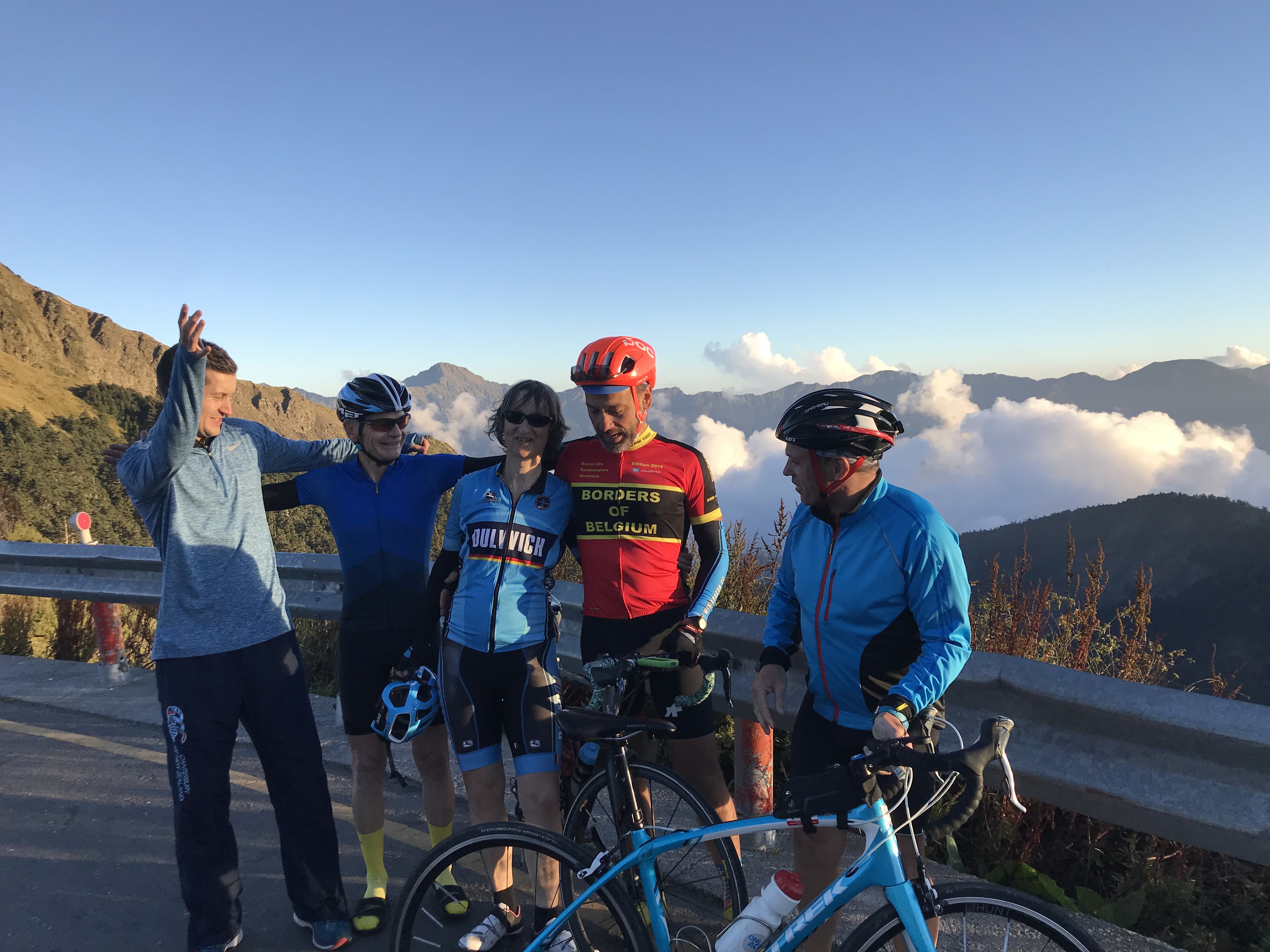 Group at mountain pass with clouds below