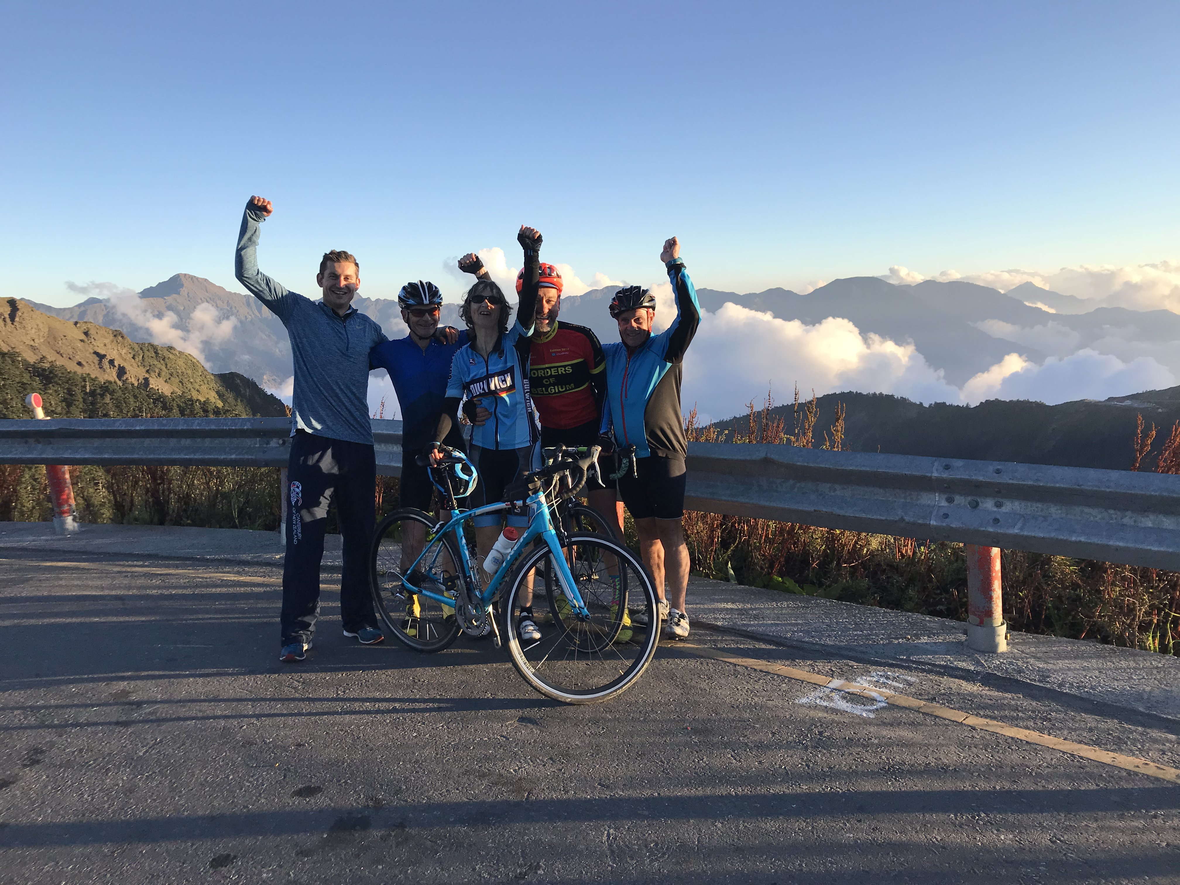 Riders at mountain overlook, valley clouds below